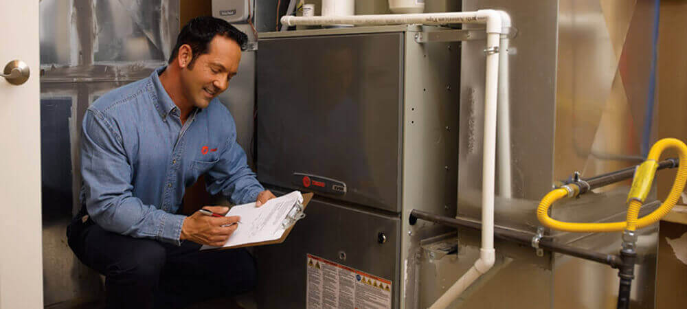 technician repairing trane heating furnace
