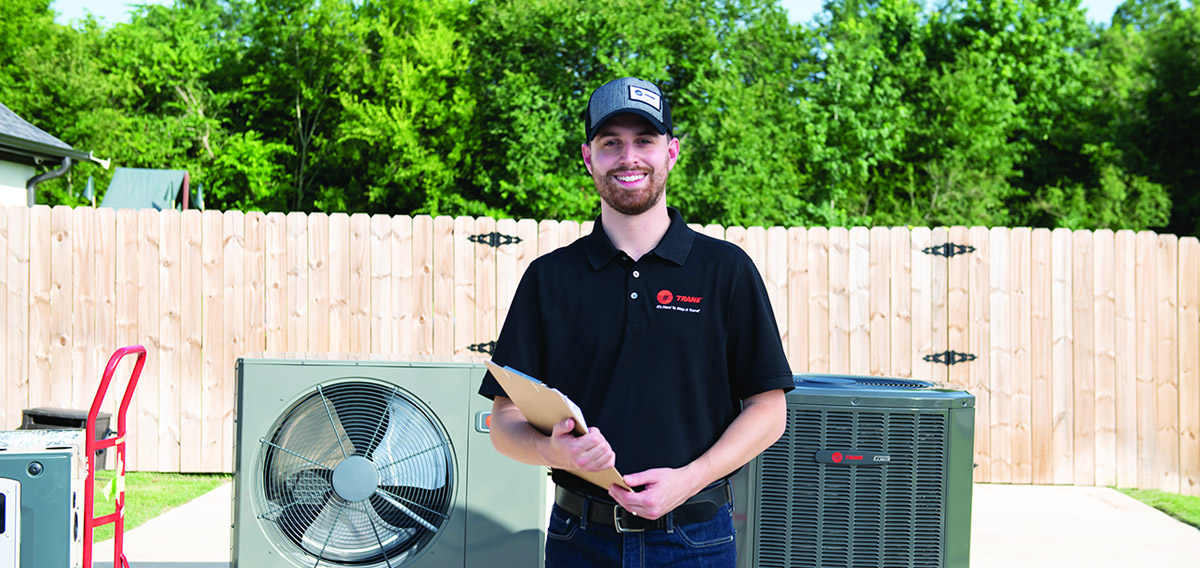 ac maintenance technician in front of hvac units